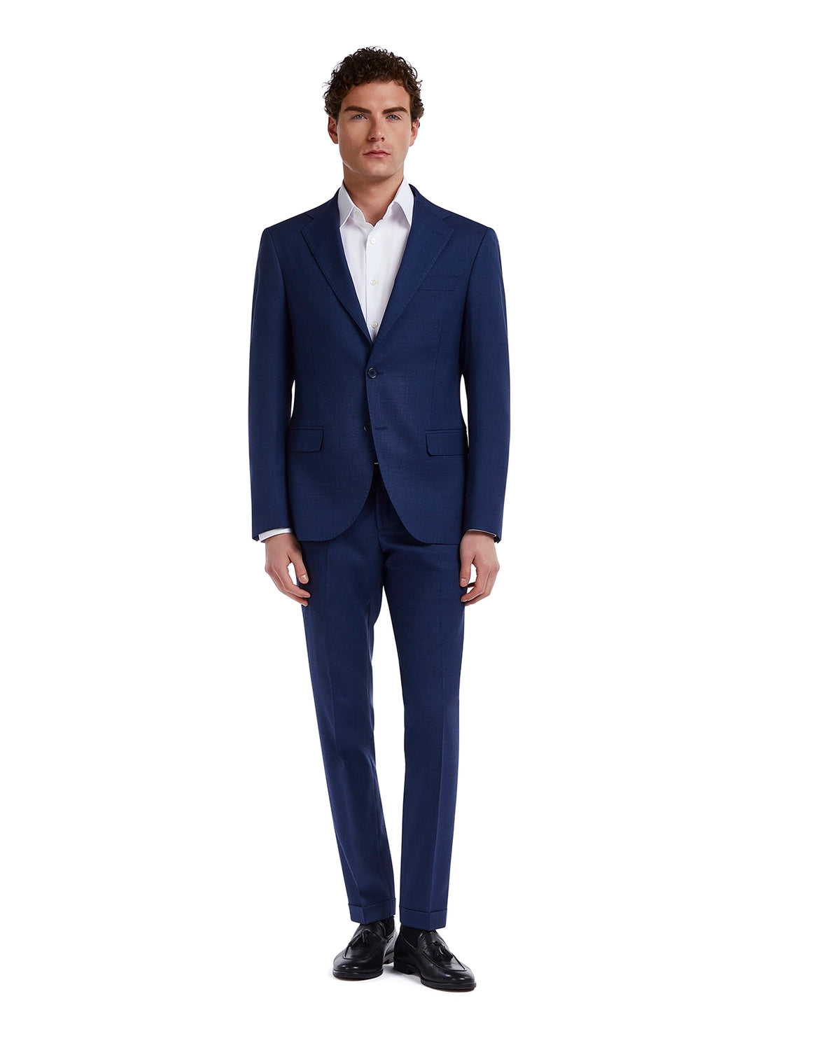 Tailored navy blue men's suit in soft wool, paired with a crisp white shirt and black leather shoes. Perfect for formal occasions.