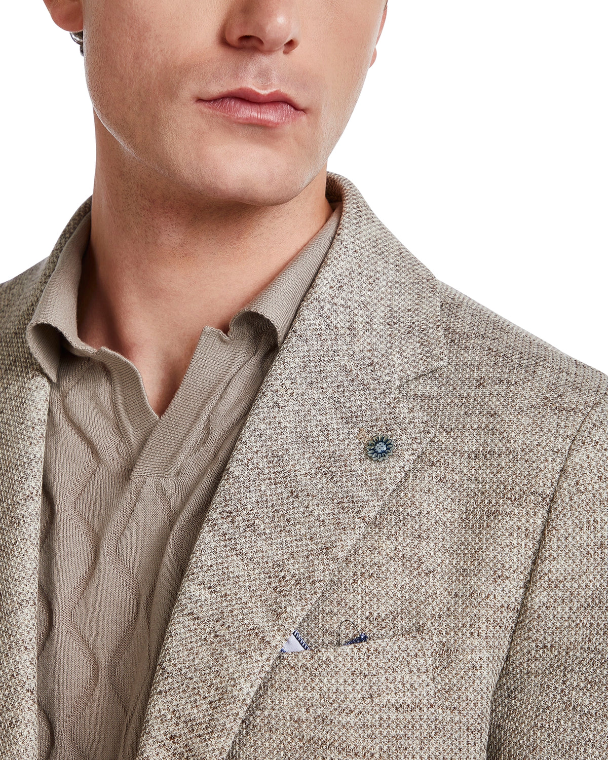 Men's beige textured blazer with a lapel pin, paired with a taupe cable-knit polo shirt.