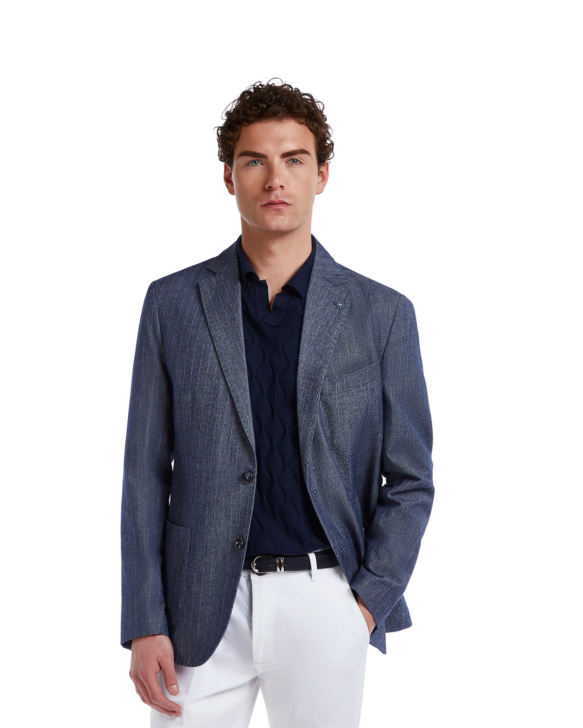 Men's navy blue striped blazer in lightweight fabric, paired with a dark blue knit shirt and white trousers.
