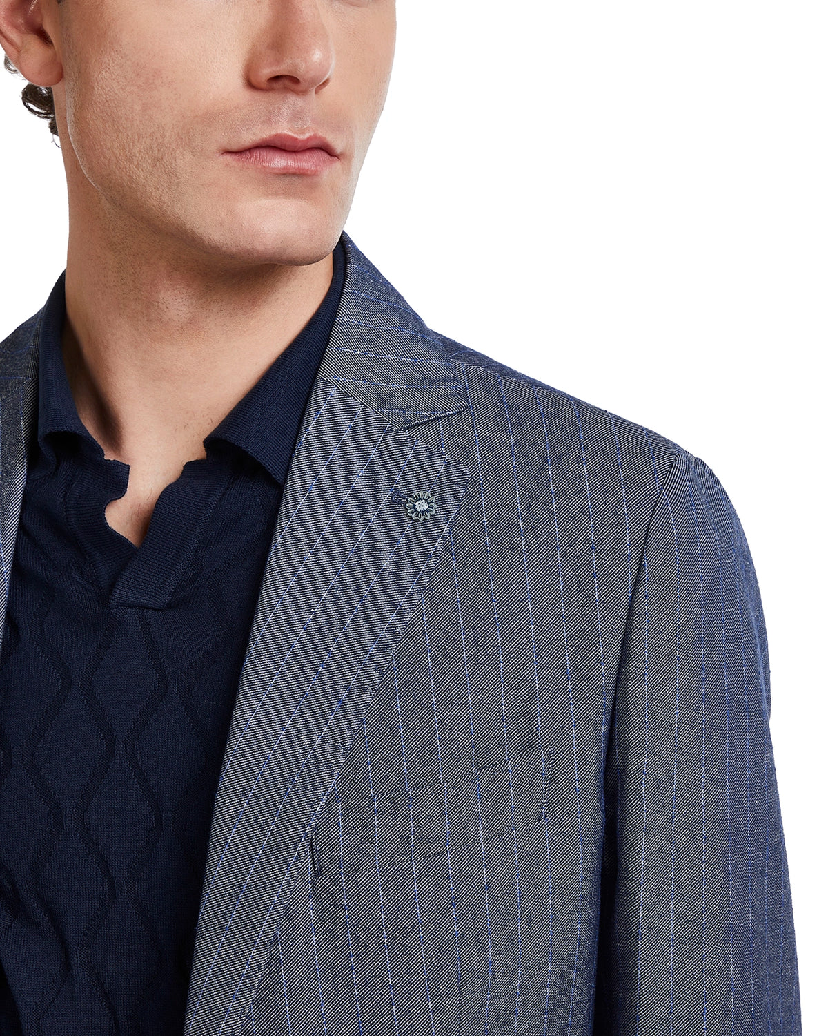 Men's tailored blue pinstripe blazer in lightweight fabric, paired with a navy knitted polo for a sophisticated look.